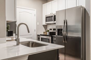 a kitchen with stainless steel appliances and a sink at Alexandria of Carmel Apartments, Carmel, IN